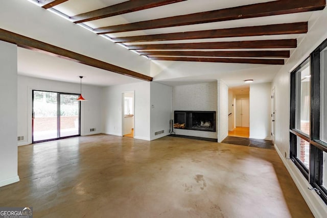 unfurnished living room featuring a fireplace, visible vents, beamed ceiling, baseboards, and concrete floors