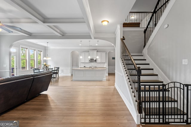 279 Sturry Dr, Mcdonough, GA 30252 - interior space featuring arched walkways, light wood-type flooring, crown molding, and beamed ceiling