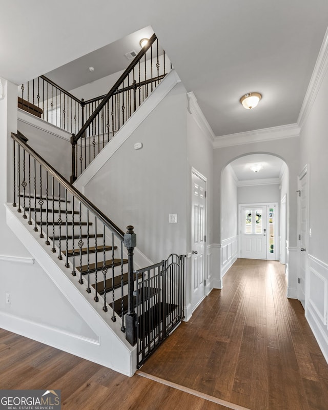 279 Sturry Dr, Mcdonough, GA 30252 - entrance foyer featuring arched walkways, wood finished floors, a decorative wall, and crown molding
