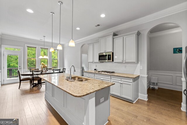 279 Sturry Dr, Mcdonough, GA 30252 - kitchen with visible vents, a sink, arched walkways, light stone countertops, and appliances with stainless steel finishes