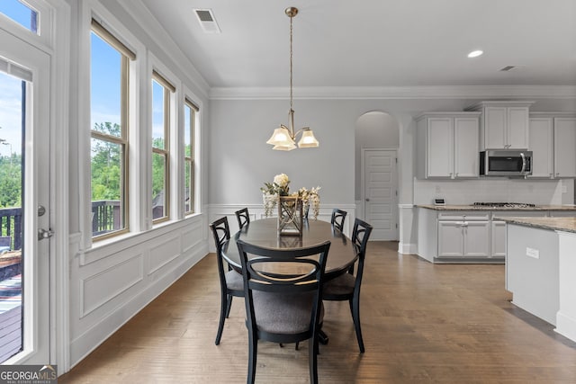 279 Sturry Dr, Mcdonough, GA 30252 - dining space with ornamental molding, arched walkways, a wainscoted wall, a notable chandelier, and visible vents