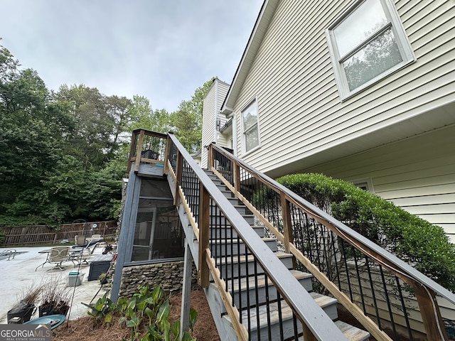 view of home's exterior with stairway, fence, and a patio area