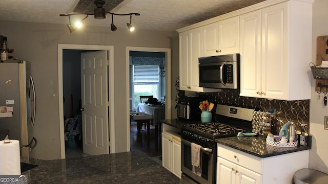 kitchen with stainless steel appliances, a ceiling fan, a textured ceiling, and tasteful backsplash