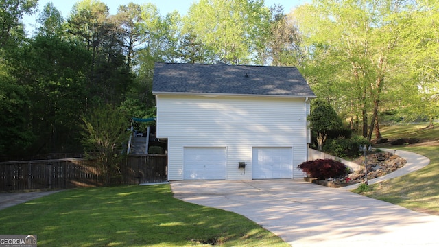 view of side of home featuring a yard, fence, driveway, and a garage