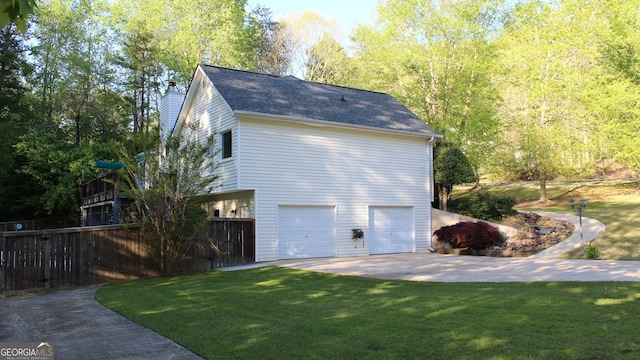 view of home's exterior featuring a lawn, an attached garage, and a chimney