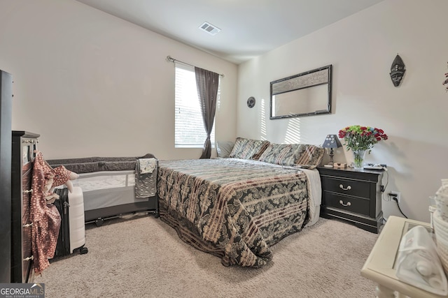 carpeted bedroom featuring visible vents