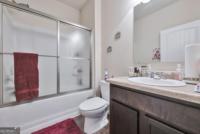 bathroom featuring shower / bath combination with glass door, wood finished floors, toilet, and vanity