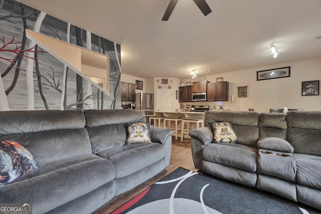 living area with visible vents, a ceiling fan, and light wood-style flooring