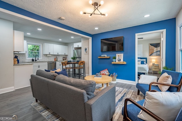 831 Catherine St, Forest Park, GA 30297 - living room with an inviting chandelier, baseboards, dark wood-style floors, recessed lighting, and a textured ceiling