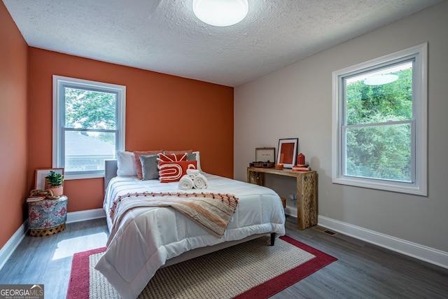 831 Catherine St, Forest Park, GA 30297 - bedroom featuring baseboards, a textured ceiling, visible vents, and wood finished floors