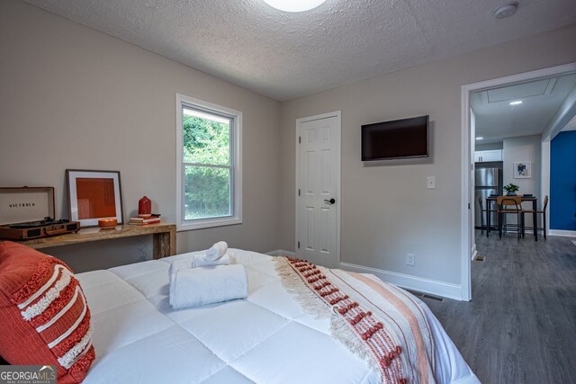 831 Catherine St, Forest Park, GA 30297 - bedroom with attic access, a textured ceiling, wood finished floors, baseboards, and freestanding refrigerator