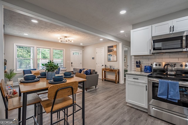 831 Catherine St, Forest Park, GA 30297 - kitchen with white cabinets, stainless steel appliances, a textured ceiling, and recessed lighting