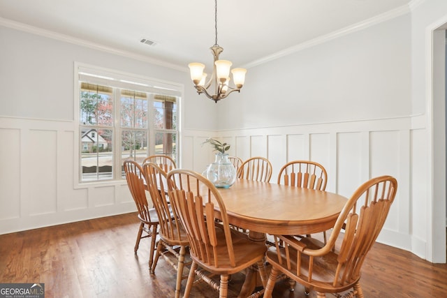 108 Turnberry Trce, Sharpsburg, GA 30277 - dining space featuring a decorative wall, crown molding, a wainscoted wall, a chandelier, and dark wood-style floors