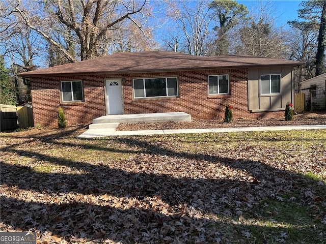 ranch-style home featuring brick siding and fence