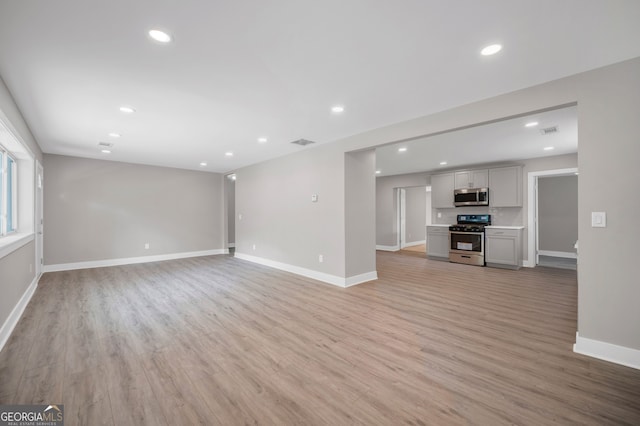 unfurnished living room with visible vents, light wood-type flooring, recessed lighting, and baseboards