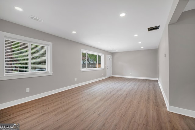 empty room featuring baseboards, visible vents, wood finished floors, and recessed lighting