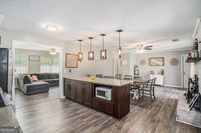 205 Tamea Trl, Covington, GA 30014 - kitchen with ceiling fan, white microwave, freestanding refrigerator, dark brown cabinets, and dark wood-style flooring