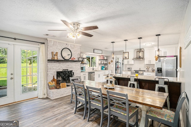 205 Tamea Trl, Covington, GA 30014 - dining area with wood finished floors, a ceiling fan, a textured ceiling, and a fireplace