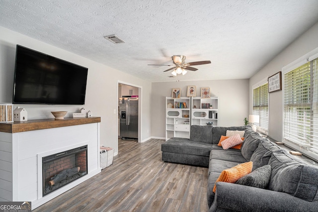 205 Tamea Trl, Covington, GA 30014 - living area with wood finished floors, ceiling fan, baseboards, a textured ceiling, and a fireplace