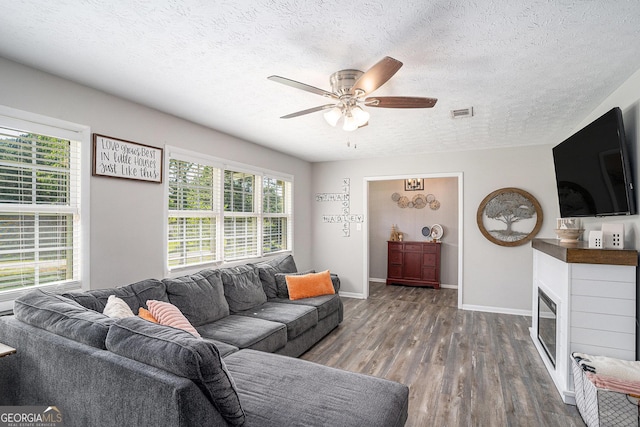 205 Tamea Trl, Covington, GA 30014 - living room with wood finished floors, a ceiling fan, baseboards, healthy amount of natural light, and a textured ceiling