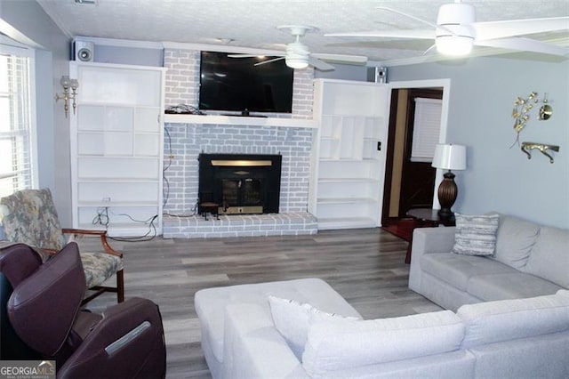 255 Deer Run Rd, Ellenwood, GA 30294 - living area with ornamental molding, a fireplace, a ceiling fan, and wood finished floors