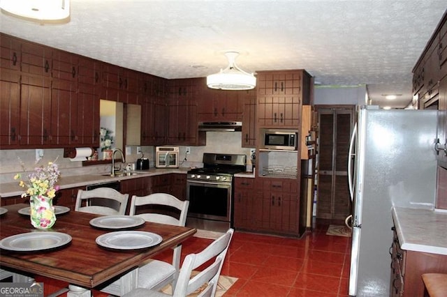 255 Deer Run Rd, Ellenwood, GA 30294 - kitchen with light countertops, under cabinet range hood, dark tile patterned flooring, a sink, and stainless steel appliances