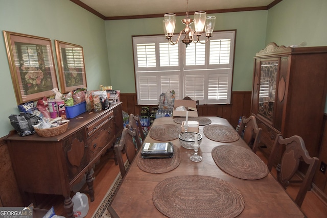 dining room featuring a chandelier, a wainscoted wall, and crown molding