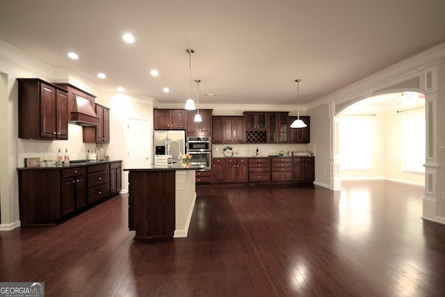 1142 Terrasol Rdg SW, Lilburn, GA 30047 - kitchen with dark wood-style floors, arched walkways, glass insert cabinets, custom range hood, and appliances with stainless steel finishes