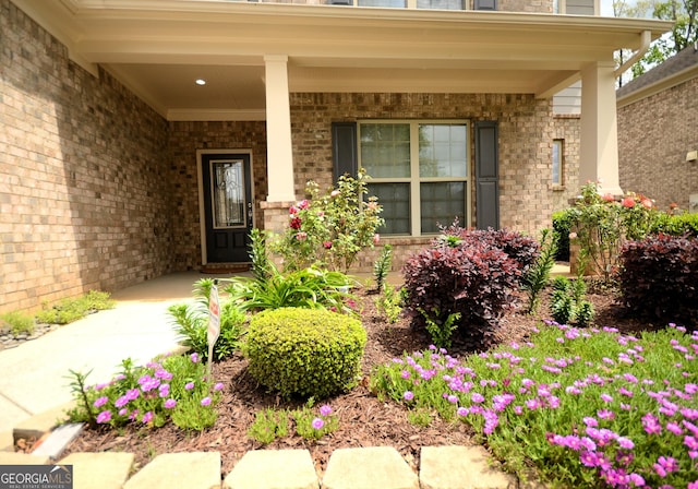 1142 Terrasol Rdg SW, Lilburn, GA 30047 - doorway to property featuring brick siding and a porch