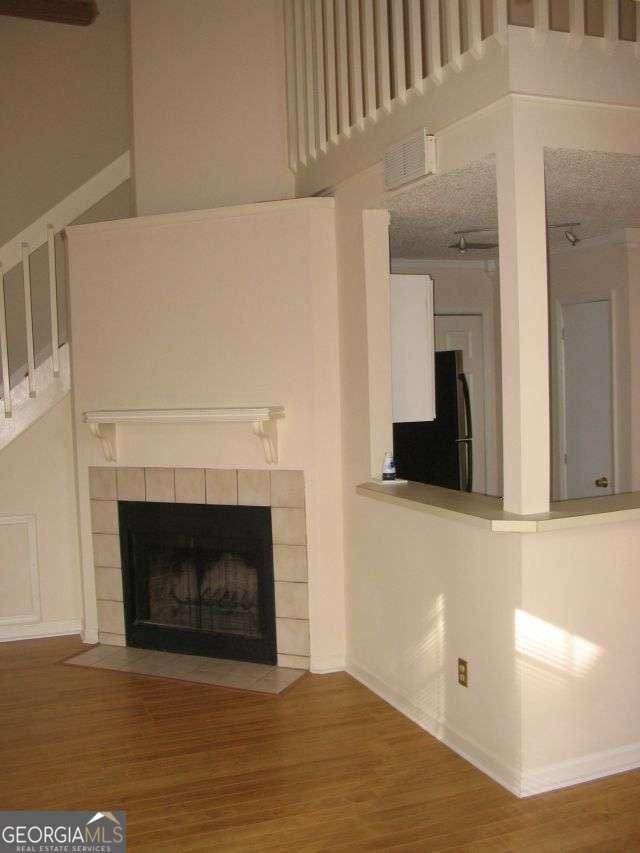 unfurnished living room with visible vents, baseboards, wood finished floors, and a fireplace