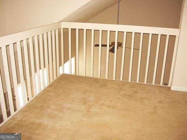 additional living space featuring lofted ceiling and carpet