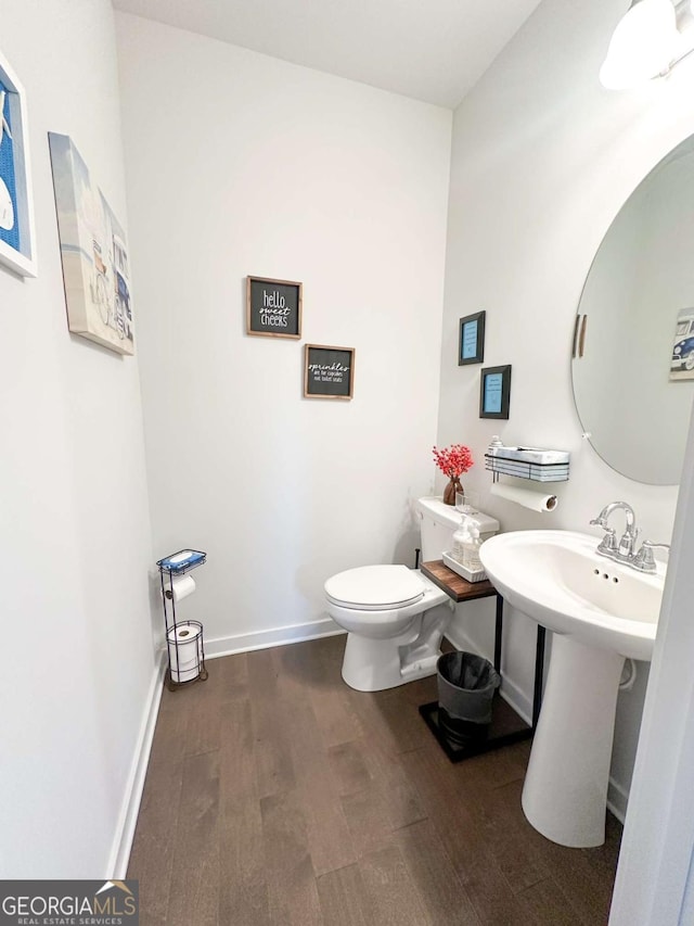 bathroom featuring wood finished floors, toilet, and baseboards