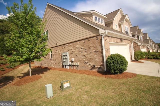 view of side of home featuring driveway, a lawn, and brick siding