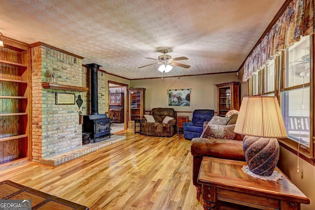 171 Wynn Dr, Hampton, GA 30228 - living area with crown molding, a wood stove, wood finished floors, a textured ceiling, and a ceiling fan