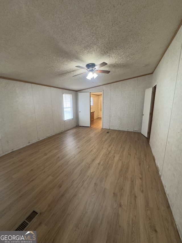 492 Garmon Rd, Cedartown, GA 30125 - unfurnished bedroom with a textured ceiling, visible vents, wood finished floors, and a ceiling fan