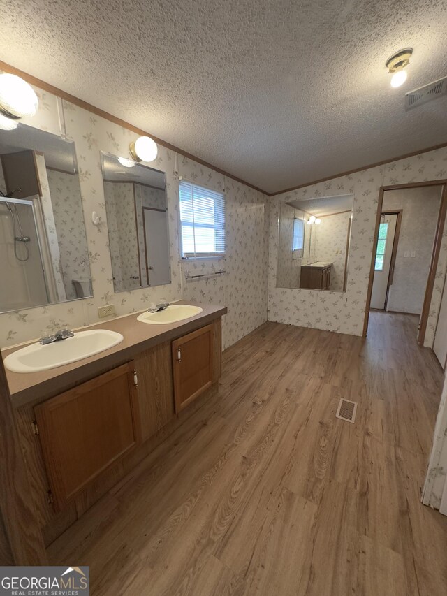 492 Garmon Rd, Cedartown, GA 30125 - full bath featuring wood finished floors, a sink, wallpapered walls, crown molding, and a textured ceiling