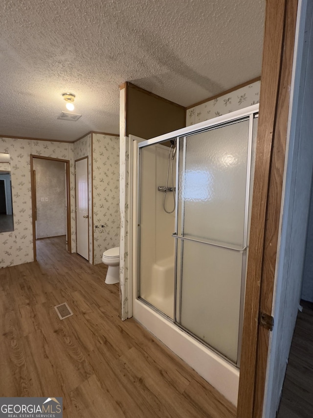 492 Garmon Rd, Cedartown, GA 30125 - full bathroom with wallpapered walls, a textured ceiling, wood finished floors, and a stall shower