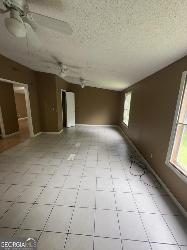 492 Garmon Rd, Cedartown, GA 30125 - empty room featuring a textured ceiling, light tile patterned flooring, a ceiling fan, and a healthy amount of sunlight