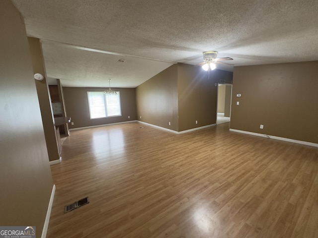 492 Garmon Rd, Cedartown, GA 30125 - empty room with lofted ceiling, ceiling fan with notable chandelier, wood finished floors, a textured ceiling, and visible vents