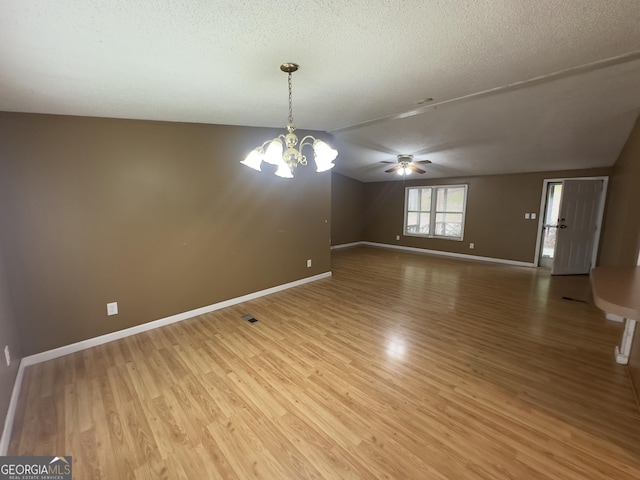 492 Garmon Rd, Cedartown, GA 30125 - spare room featuring light wood-style flooring, ceiling fan with notable chandelier, a textured ceiling, baseboards, and vaulted ceiling