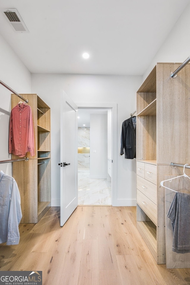 walk in closet with visible vents and light wood-type flooring