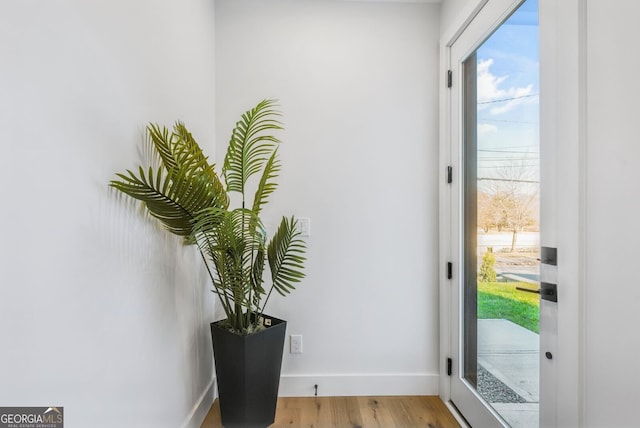 doorway featuring light wood-style floors and baseboards