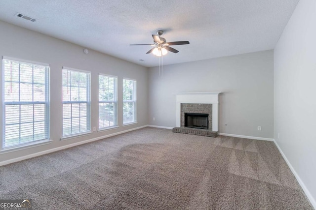 unfurnished living room with a textured ceiling, visible vents, ceiling fan, carpet flooring, and baseboards