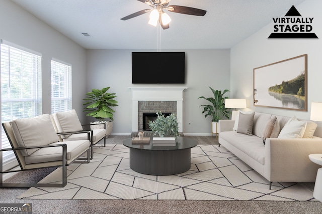 living room with a ceiling fan, baseboards, visible vents, a fireplace, and light colored carpet
