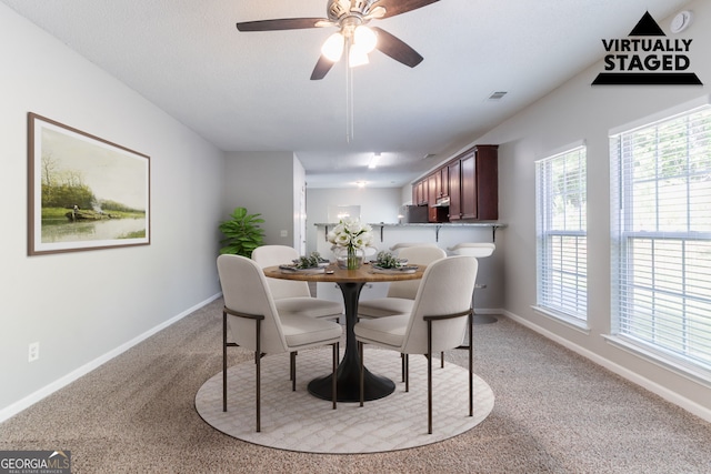dining room with baseboards, ceiling fan, visible vents, and light colored carpet