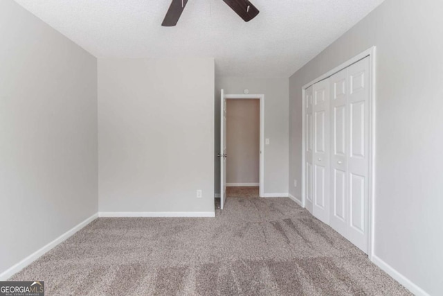 unfurnished bedroom with carpet flooring, a closet, and baseboards