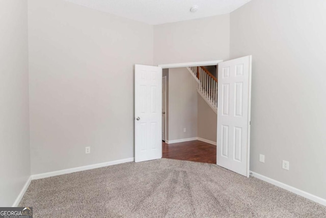 carpeted empty room with baseboards