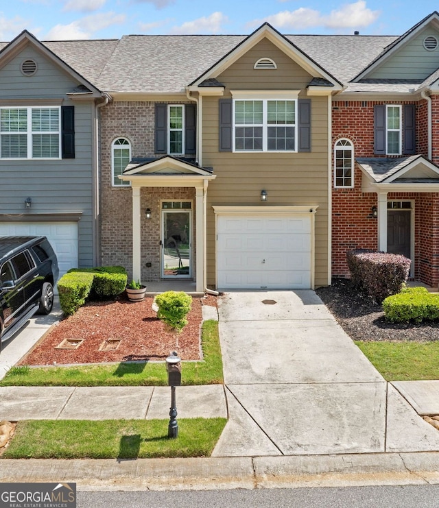 view of front of house with a garage, driveway, roof with shingles, and brick siding