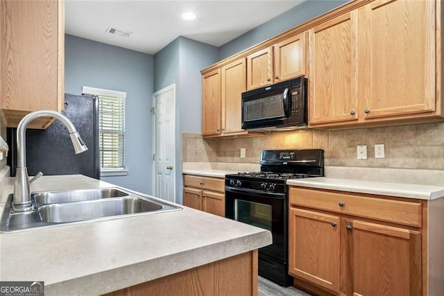 kitchen with a sink, light countertops, tasteful backsplash, visible vents, and black appliances