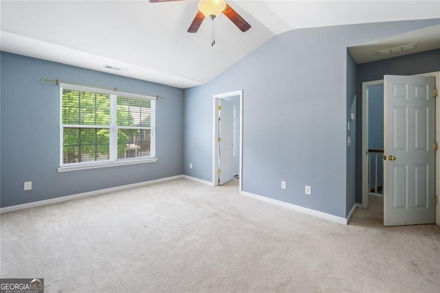 unfurnished bedroom with baseboards, visible vents, lofted ceiling, and carpet